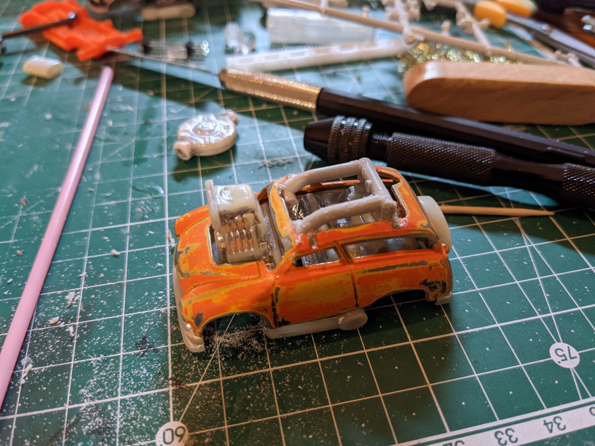 I took the car apart. Sanded the paint a bit, removed the transparent part and started adding some details.